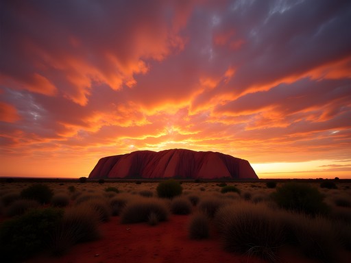 Woman watching magnificent Uluru sunrise with coffee