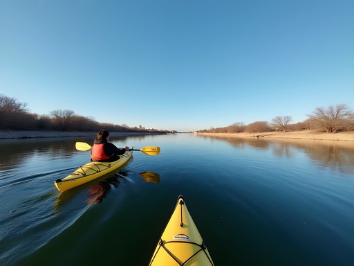 Solo traveler kayaking on the calm waters of the Rio Grande with Laredo and Nuevo Laredo visible on opposite shores