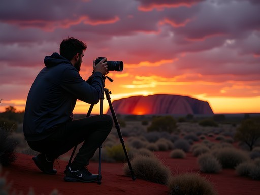 Environmental scientist photographing Uluru at sunrise with tripod
