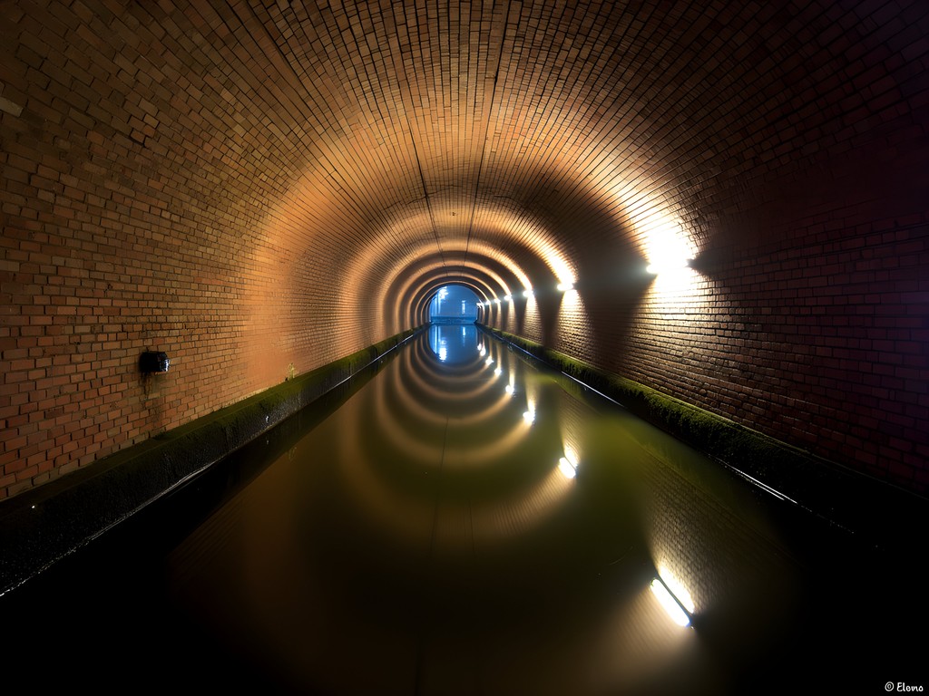 Atmospheric brick tunnel of Manchester's underground canal system with reflective water